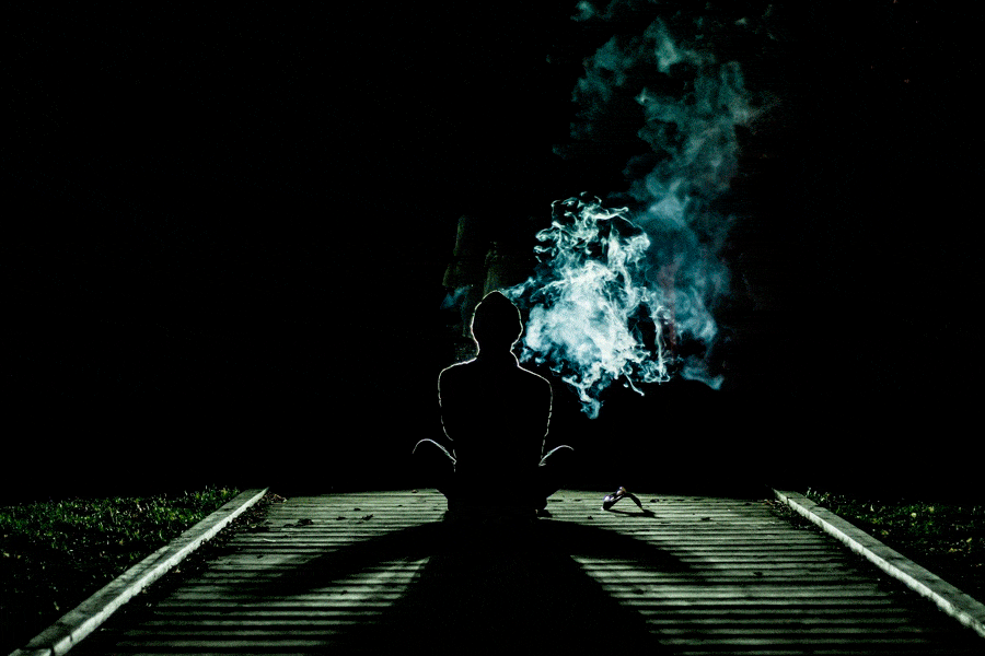 una persona sentada en el suelo en la noche