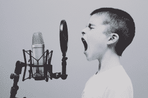 niño gritandole a un micrófono